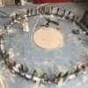 The wheel is 5' across I laid out the circle with a string and cut sections on a band saw and hot glued them to the floor